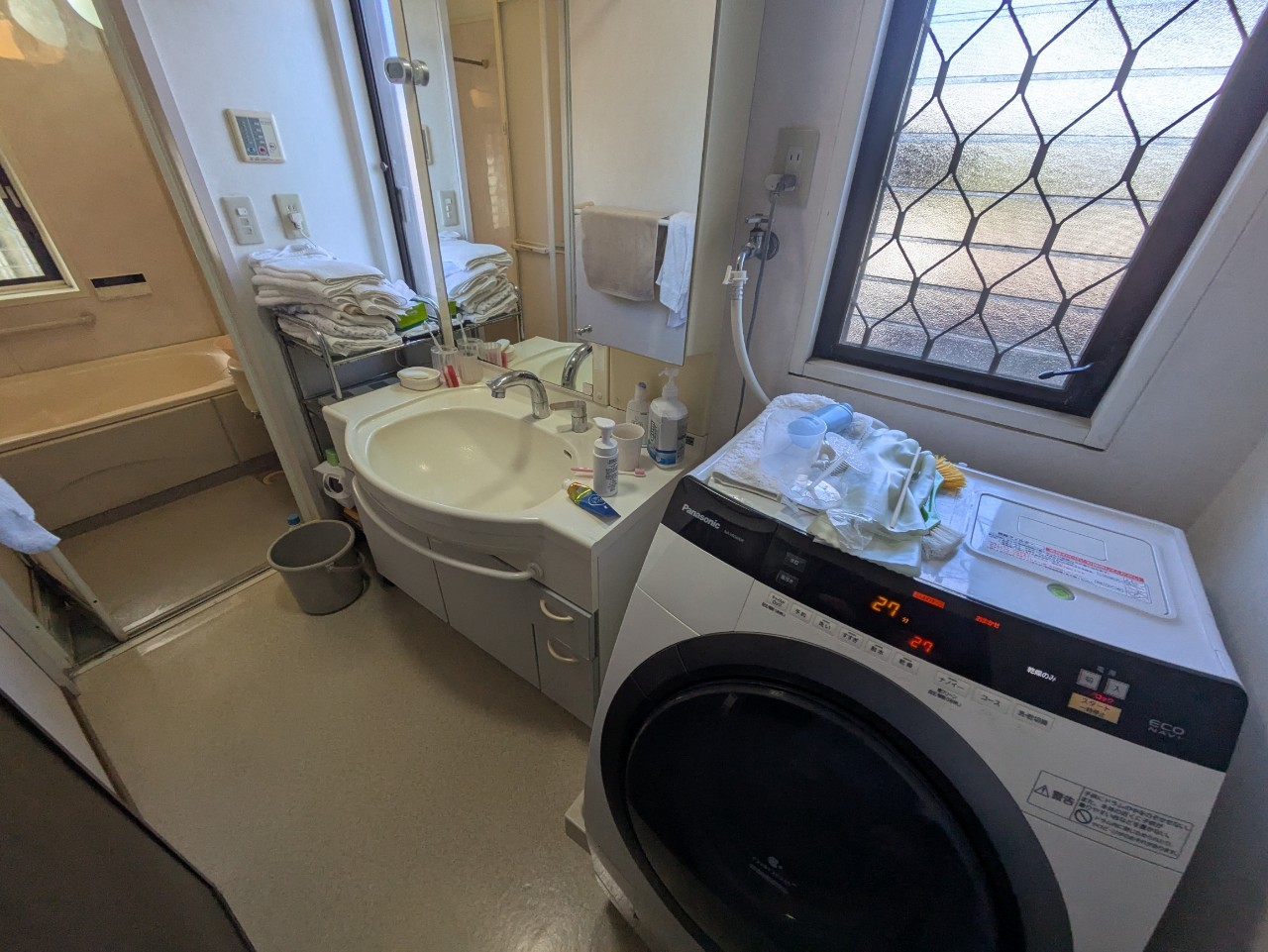 北区赤羽北 マンション洗面室 旧型洗面台と洗濯機配置の施工前状況