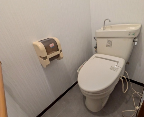 トイレ室内の正面アングル｜クロス張り替え済みの清潔感ある洋式トイレ