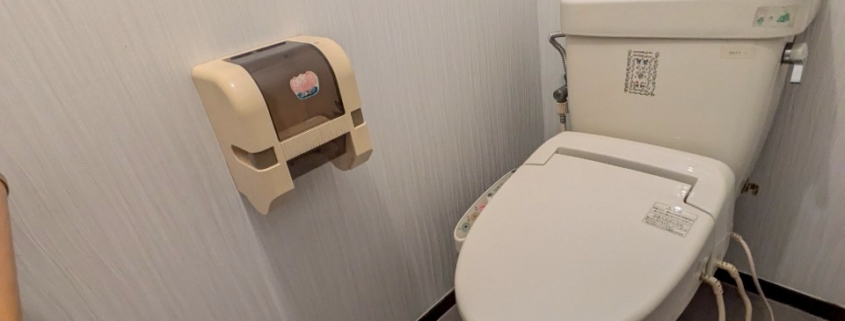 トイレ室内の正面アングル｜クロス張り替え済みの清潔感ある洋式トイレ