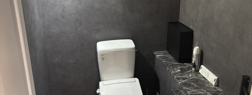 葛飾区白鳥の店舗トイレリフォーム施工後の内装空間(ダークグレー壁クロスと石目カウンター)